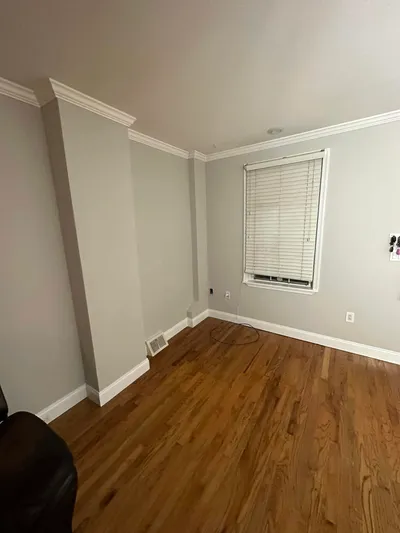 Gray living room with crisp white crown molding and baseboards