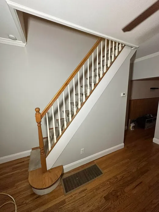 Stairway with freshly painted white spindles and gray walls by Quality Brush Painting